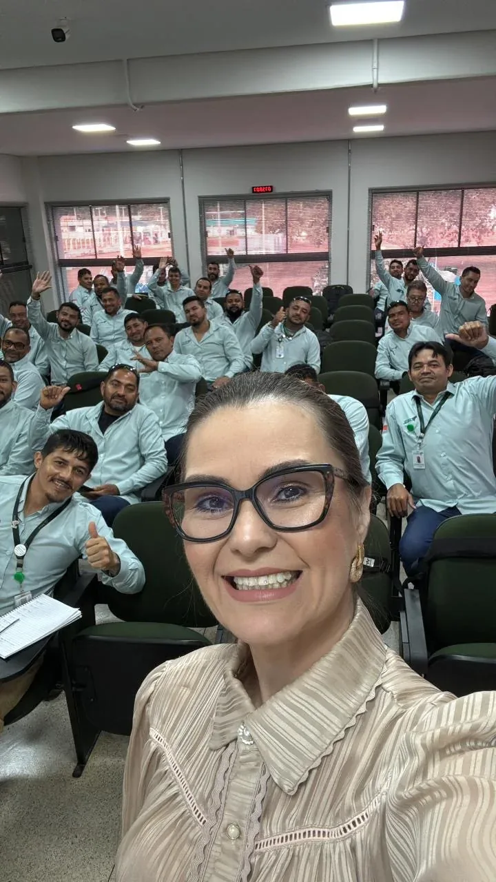 Carla Cândido com participantes de um treinamento em auditório